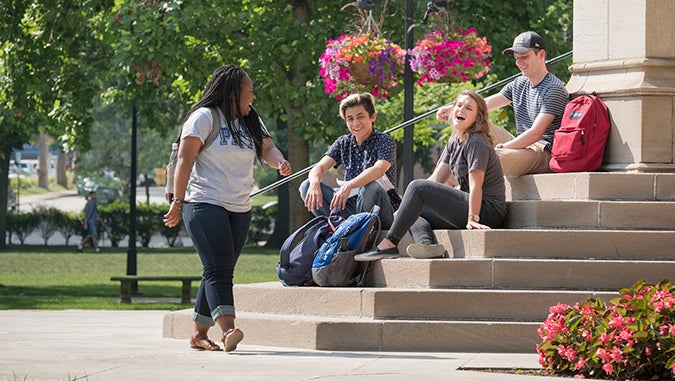 Pitt students talking and laughing outside on campus