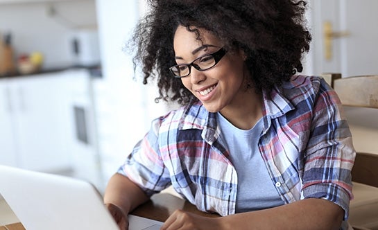 Woman smiling working on laptop