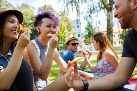 Students outside eating pizza