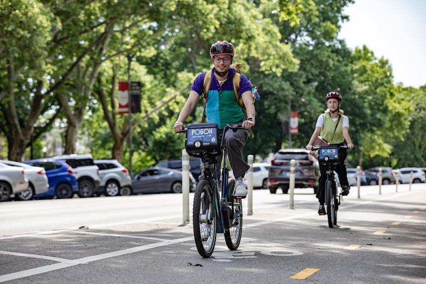 Two people riding POGOH Bikes