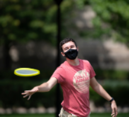 Student playing frisbee outdoors