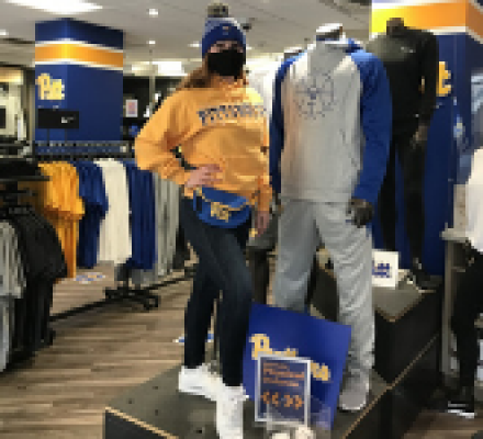 A woman modeling Pitt gear inside the University Store