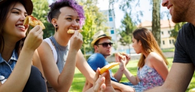Students outside eating pizza