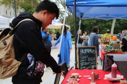 student shopping at the farmer's market